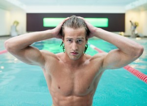 Man touching wet hair at swimming pool